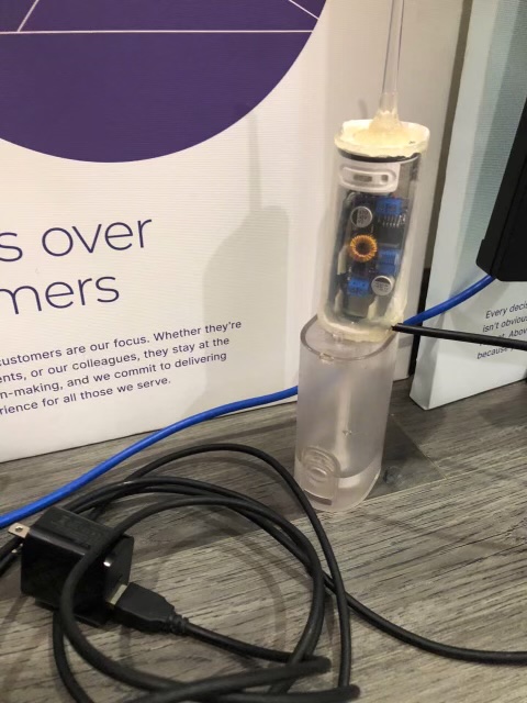 The finished flosser standing upright, running off a wall adapter