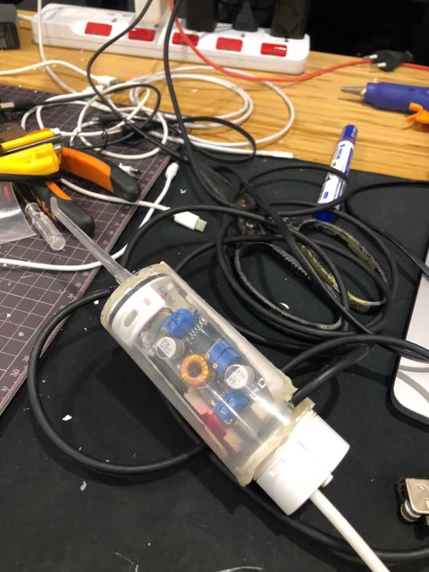 The flosser put back together on the workbench, electronics visible through the translucent body